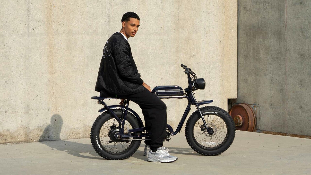 Rider sitting on Period Correct collab with concrete backdrop