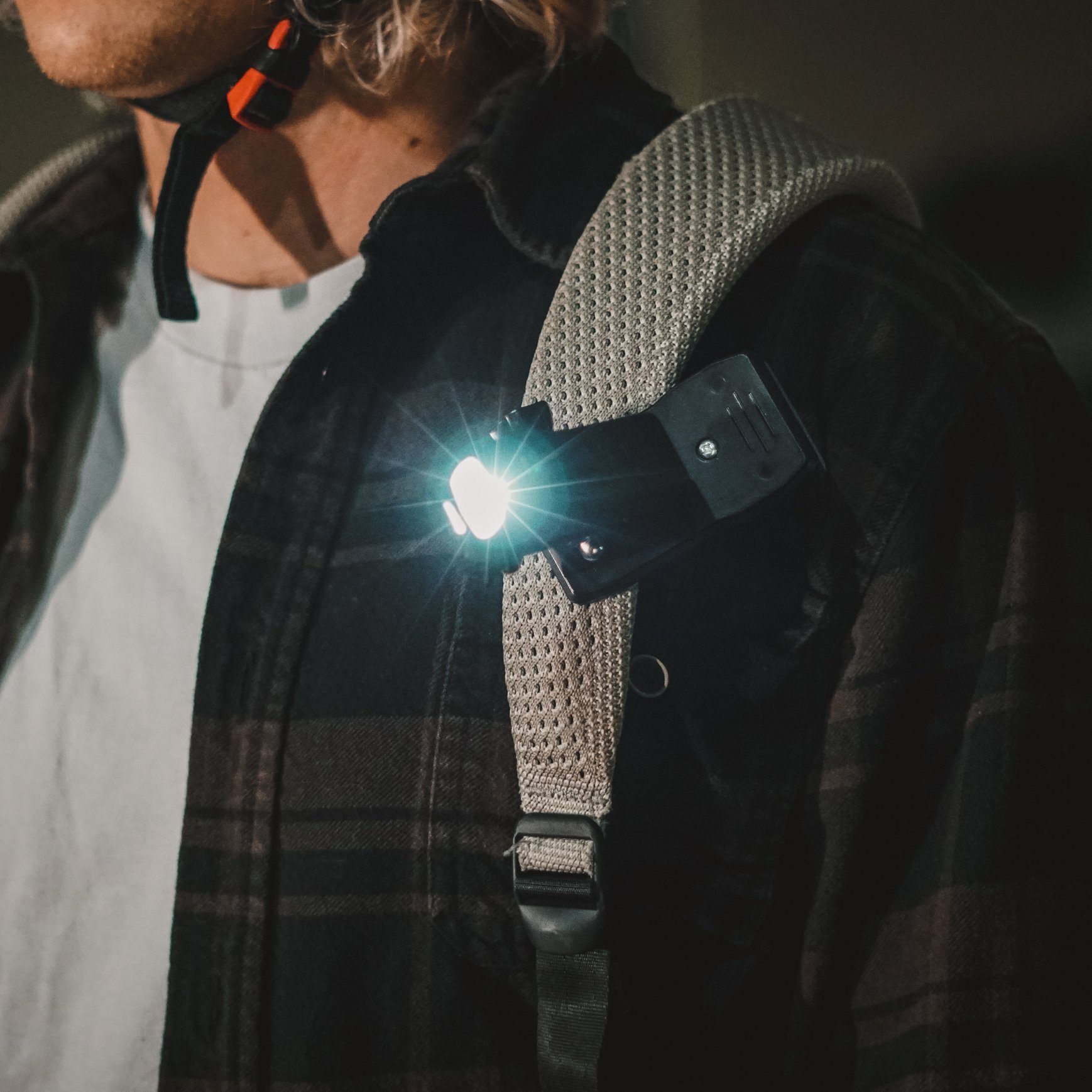 Action Clip by ShredLights clipped to backpack shoulder strap at night.