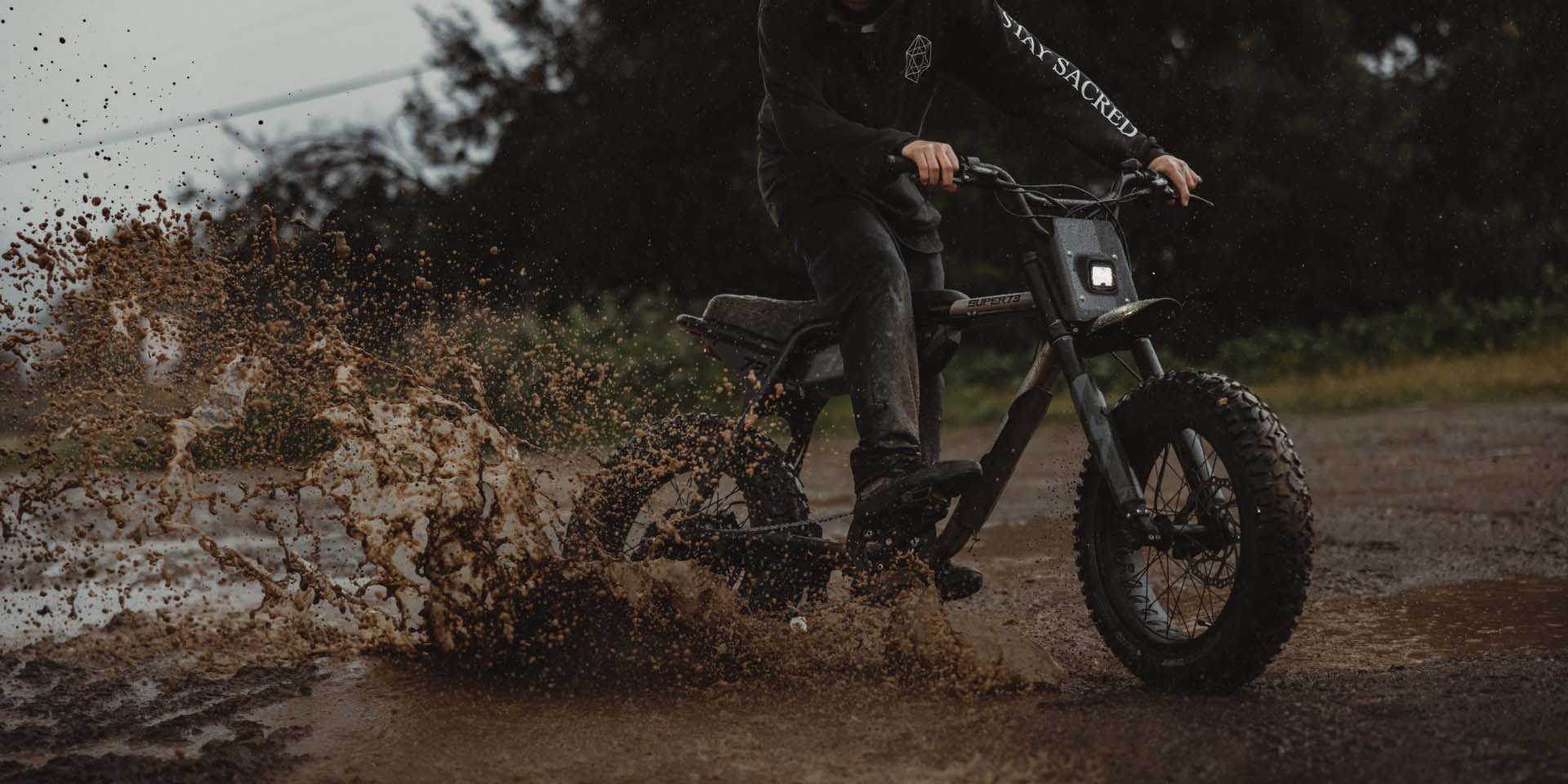 Closeup of rider skidding through the mud on a Super73 Adventure Series bike