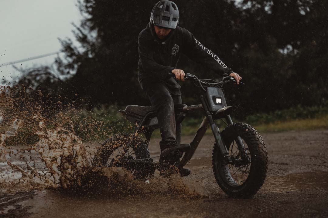 Closeup of rider skidding through the mud on a Super73 Adventure Series bike