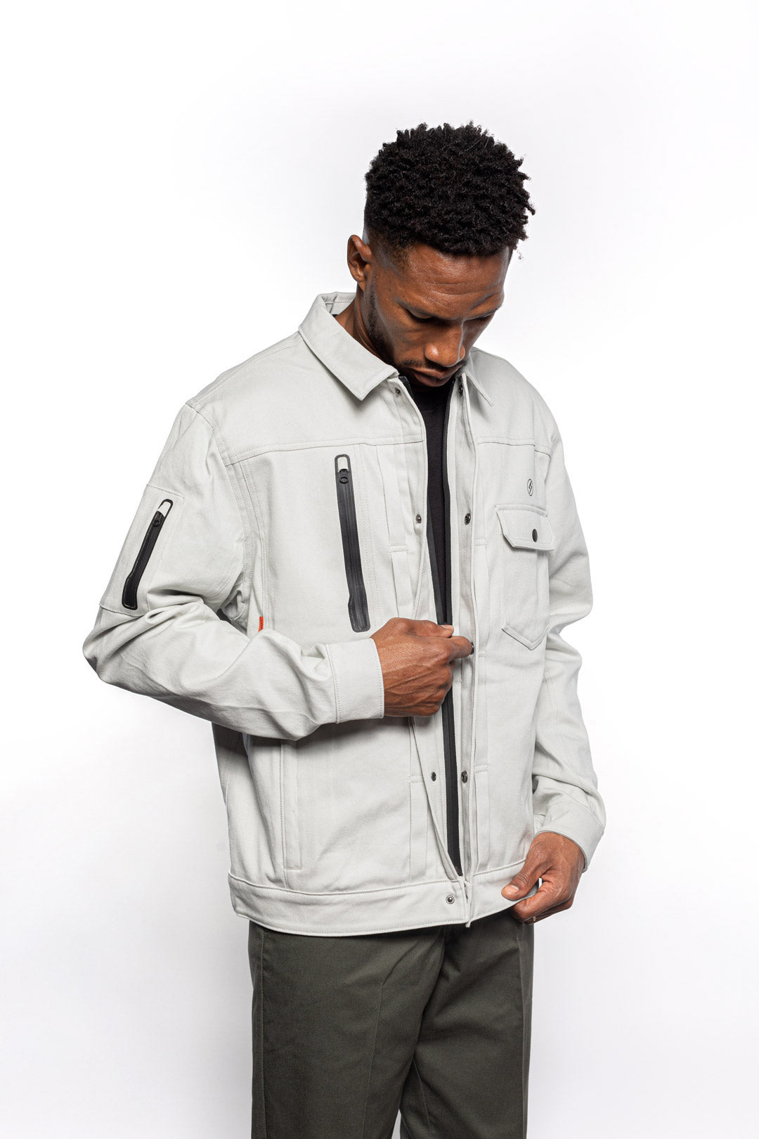 Side view of Male model zipping Anvil Chore Jacket in chalk colorway.