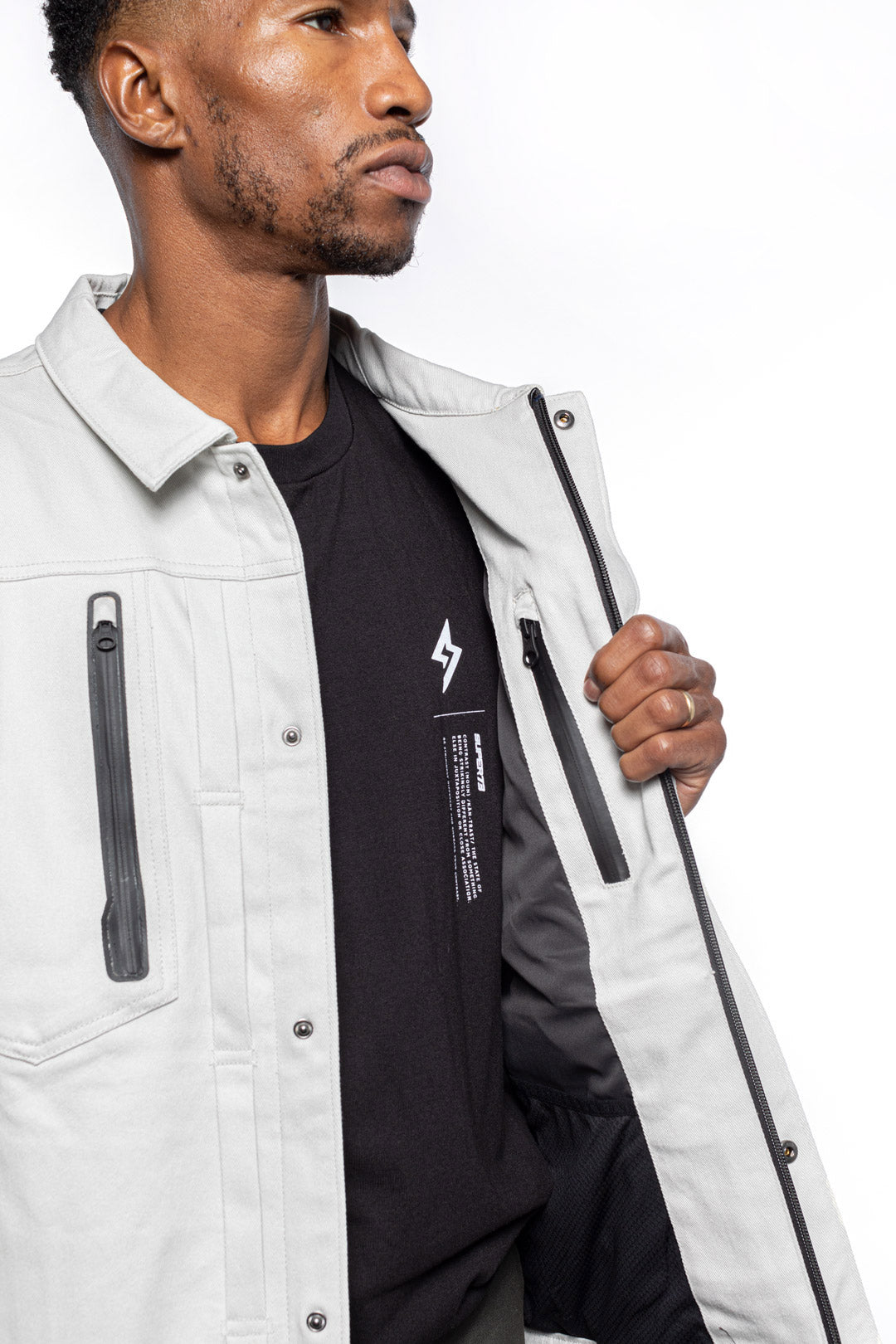 Male model wearing Anvil Chore Jacket in chalk colorway showing inside details.
