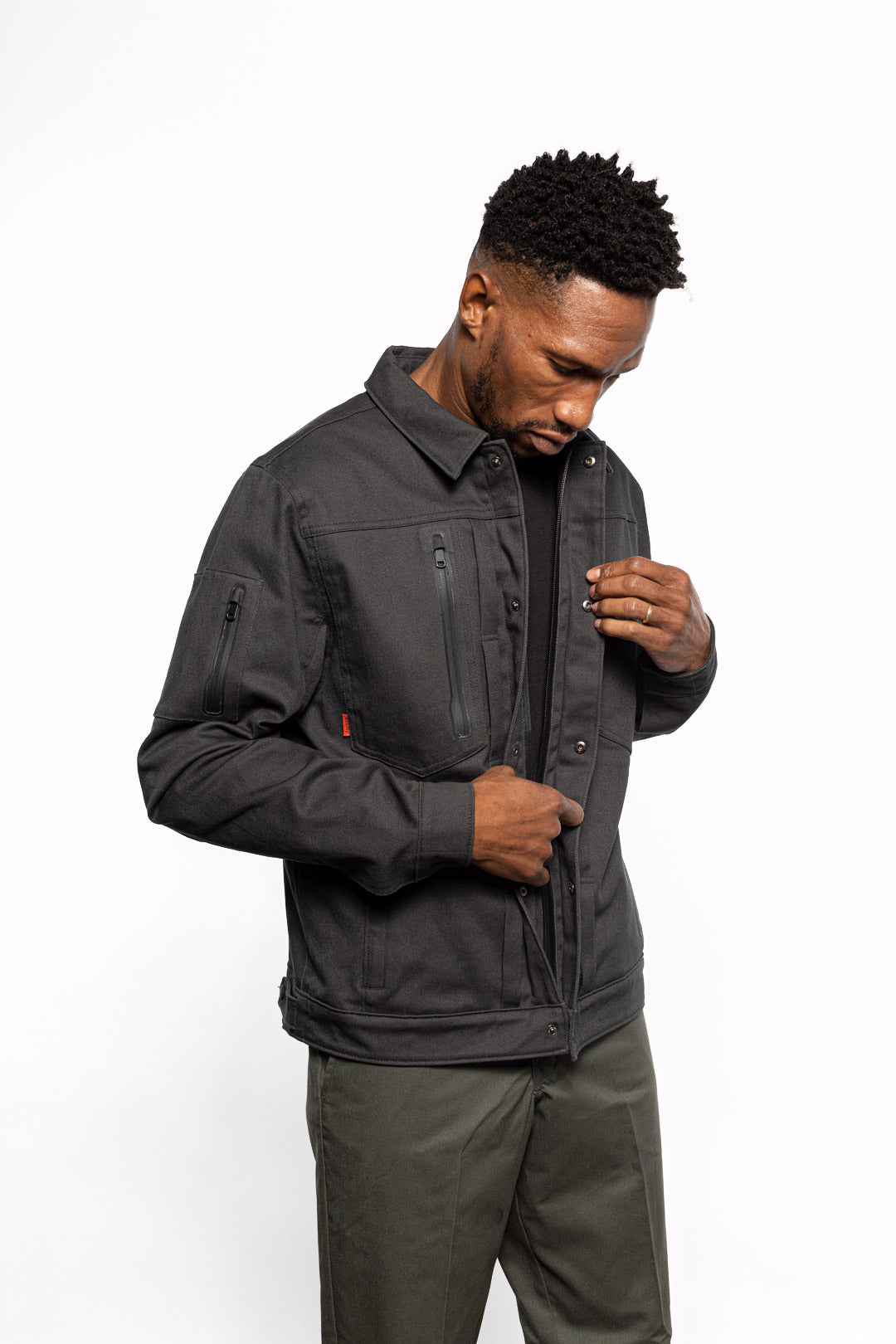 Male model zipping Anvil Chore Jacket in gravel colorway.