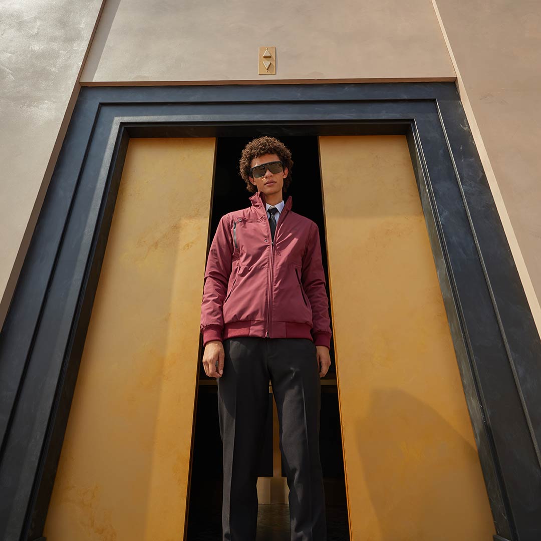 Model emerging from elevator wearing Burgundy Anvil FRD jacket