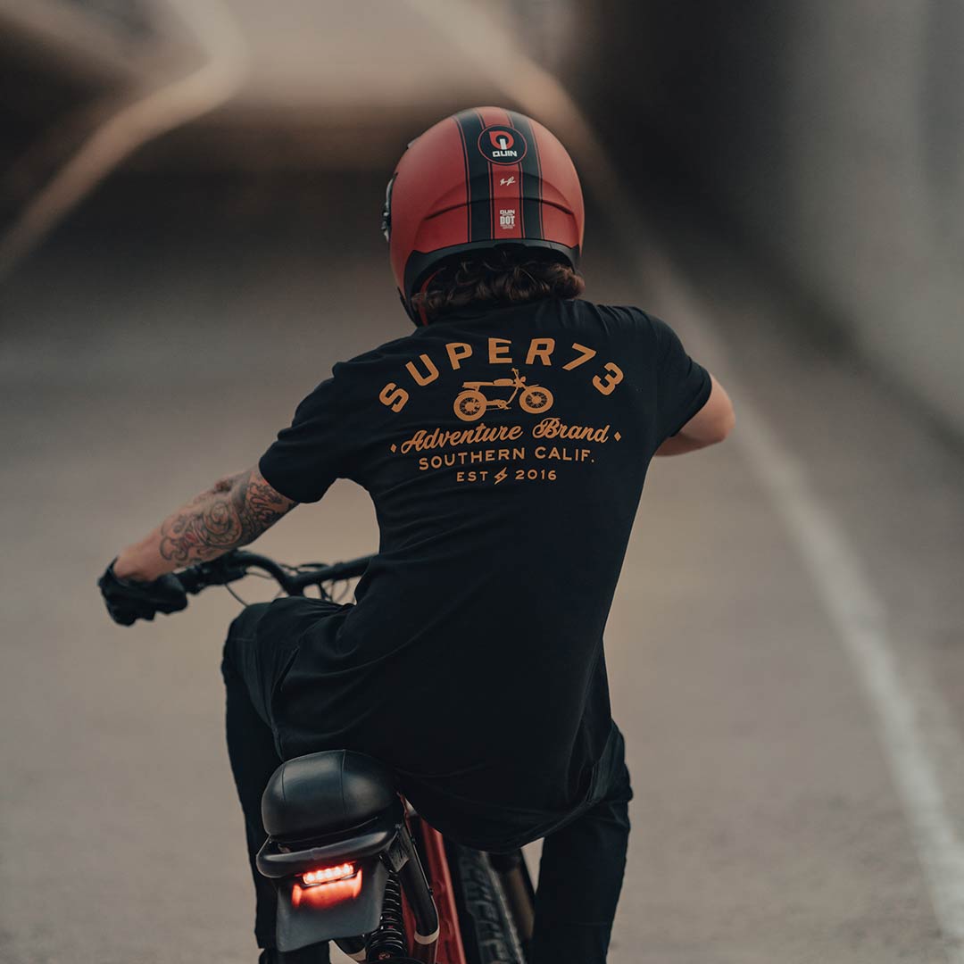 Super73 rider on short sleeve t-shirt heading into an underpass