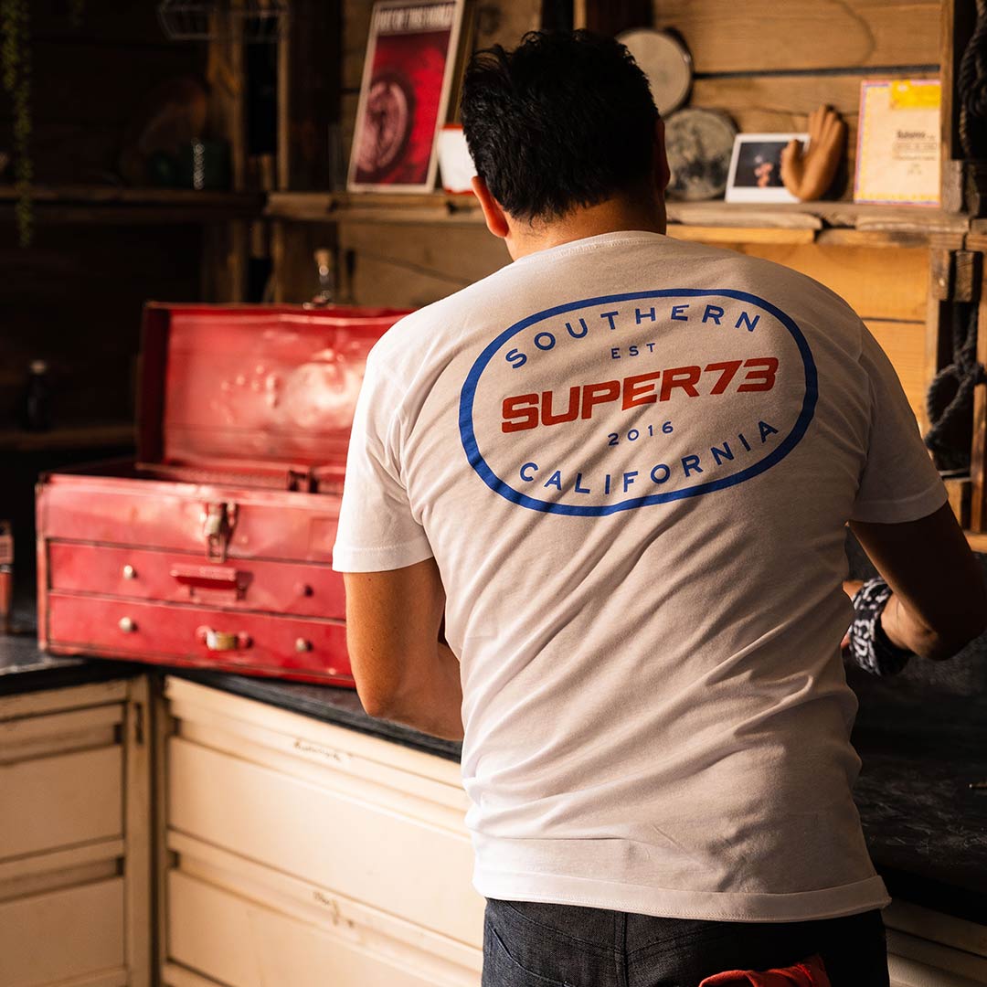 Person wearing White super73 tshirt while working in the workshop