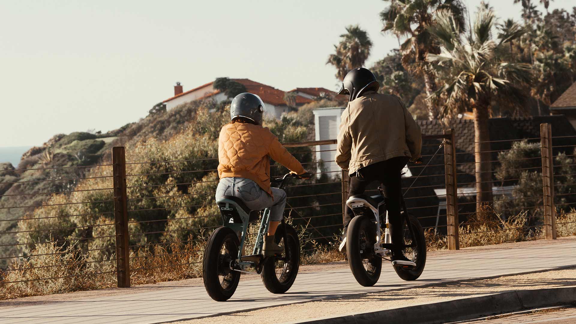 Couple riding Super73 ebikes on a coastal bike path