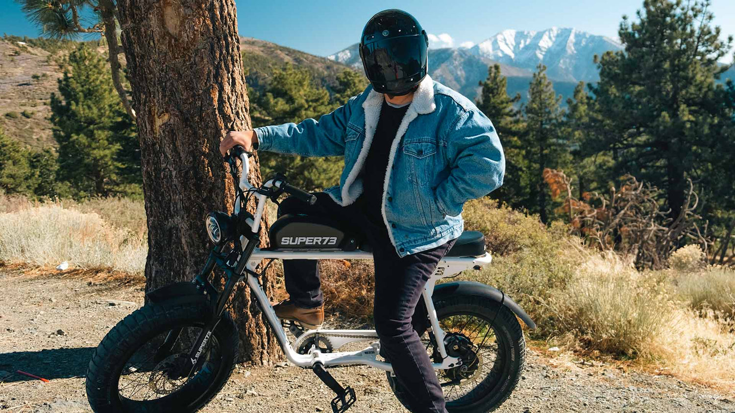 Rider on Super73 S2 on mountain trail posing with snowy peak in the background