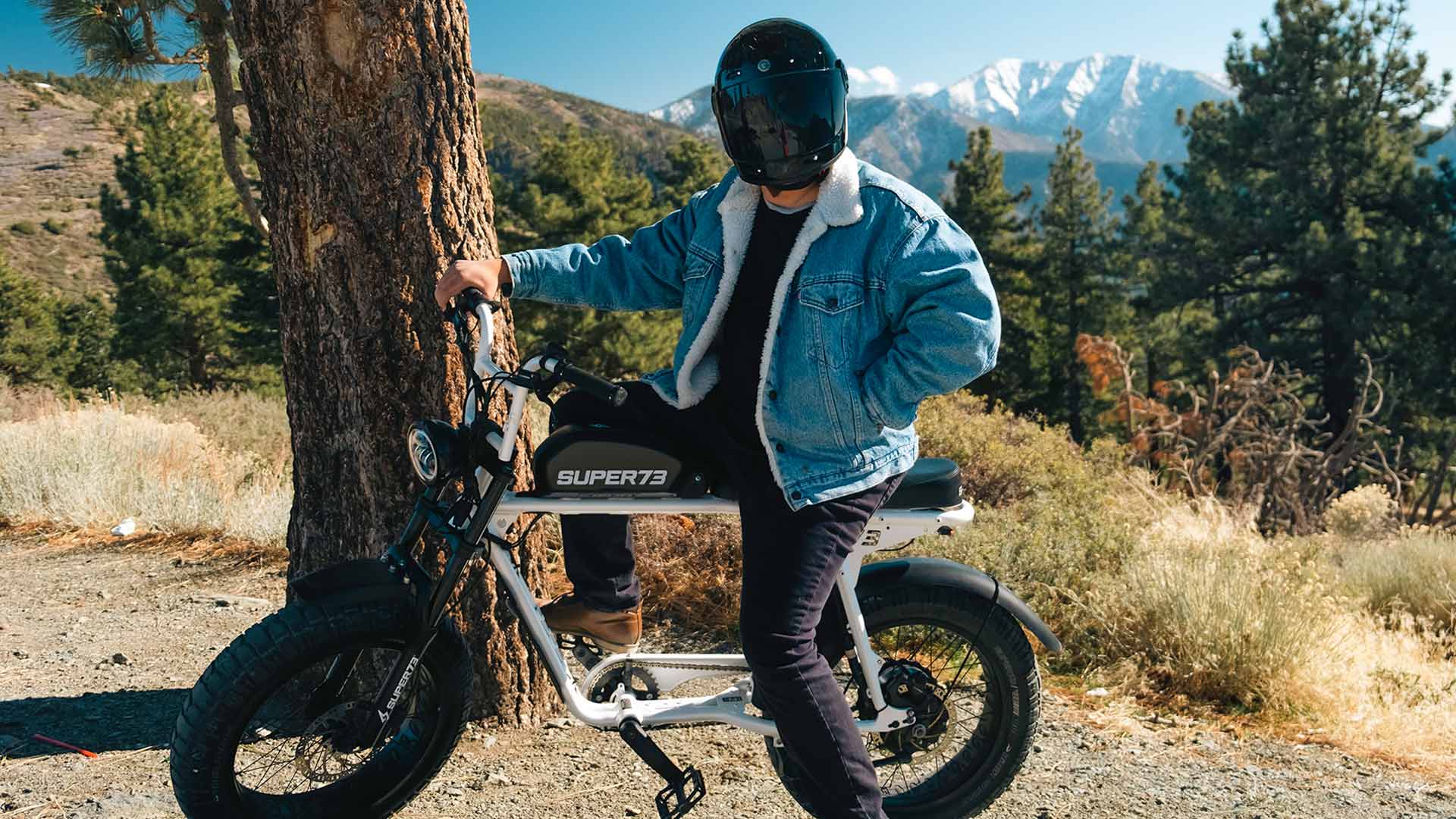Rider on Super73 S2 on mountain trail posing with snowy peak in the background