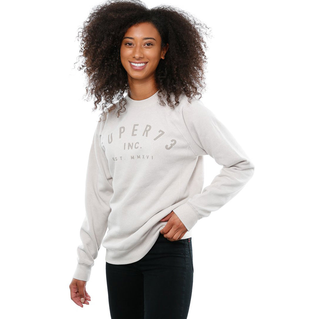Side view of female model in Stone Classic Crew Sweatshirt on white background.