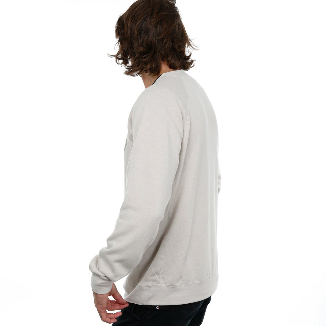 Side view of male model in Stone Classic Crew Sweatshirt on white background.