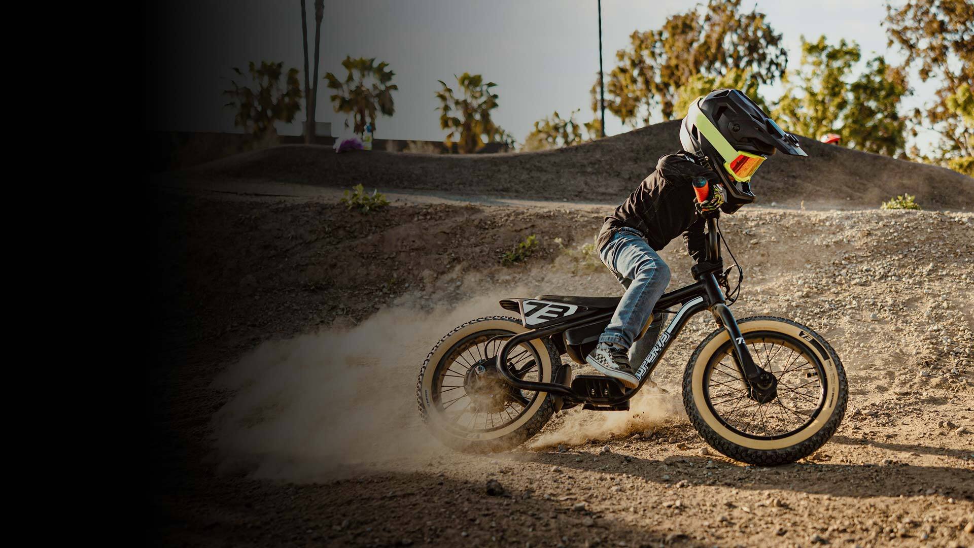 A kid riding his K1D on a pump track having the best time of his life.