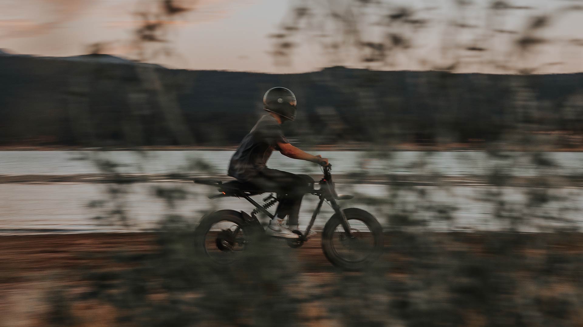 A man riding a SUPER73 by a river.