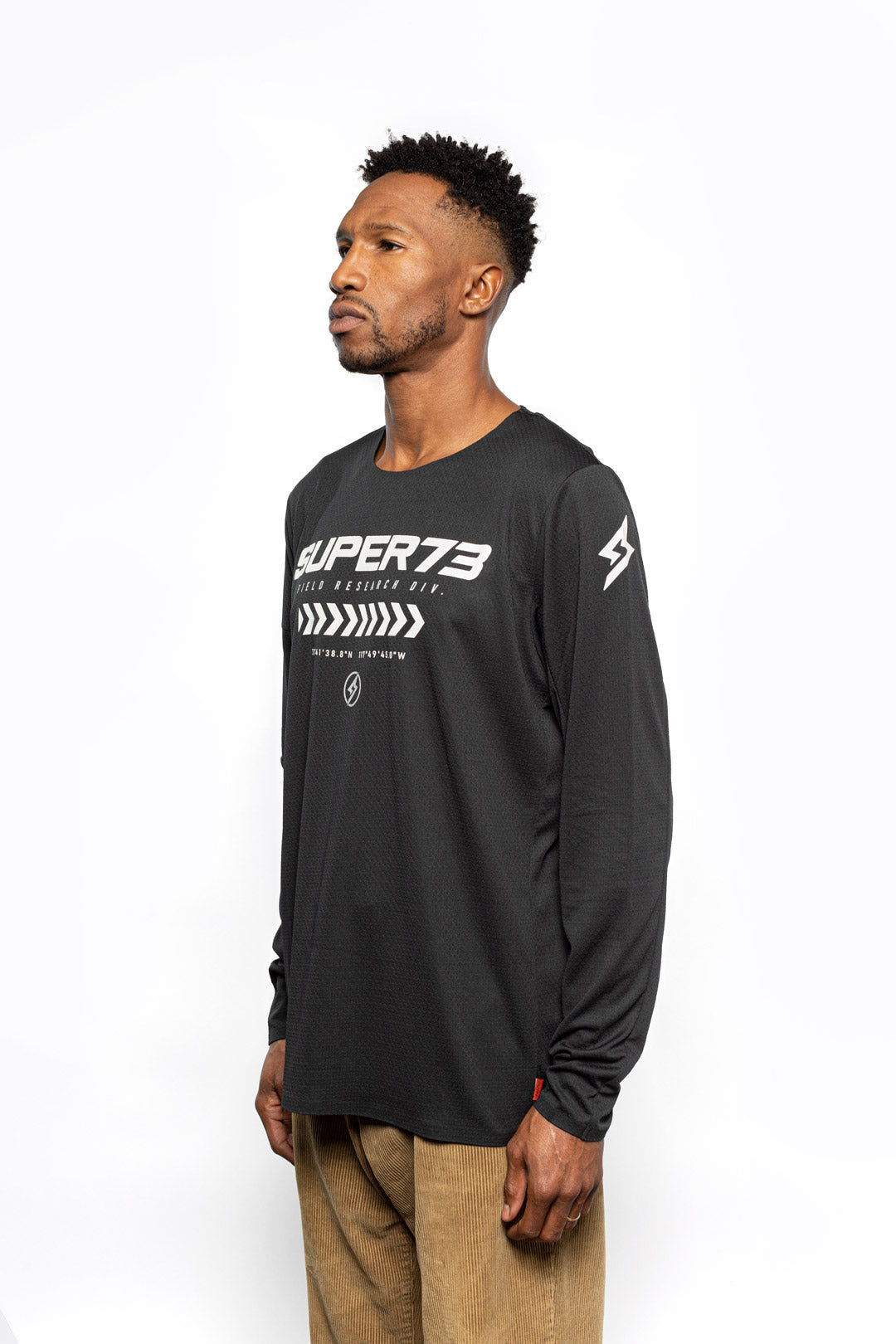 Male model side view of black Premium long sleeve athletic moto hoon jersey.