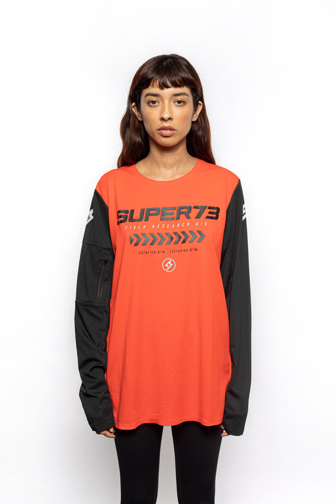 Female model front view of orange Premium long sleeve athletic moto hoon jersey.