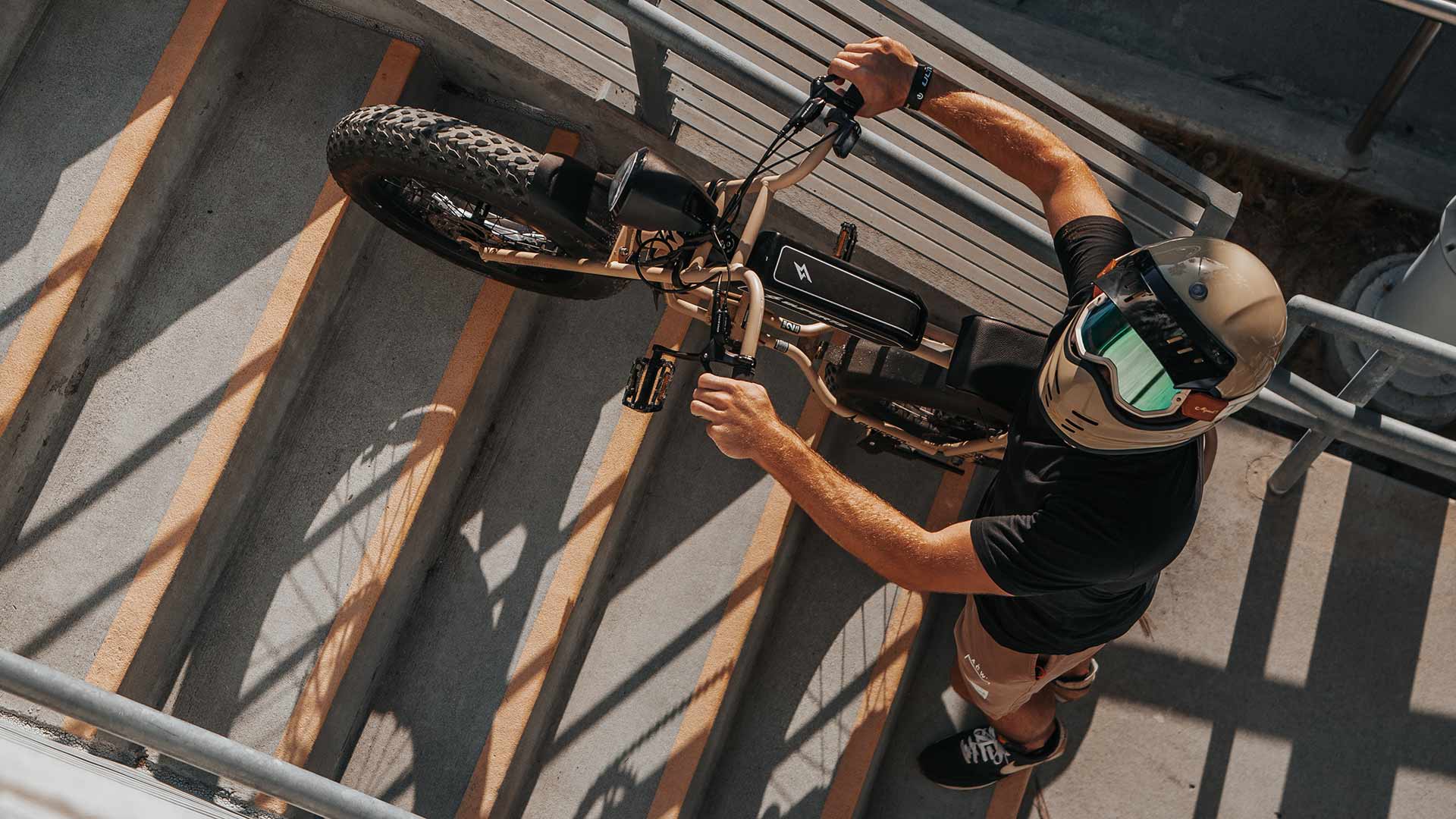 Rider ascending stairs on Super73 ebike while looking up at camera