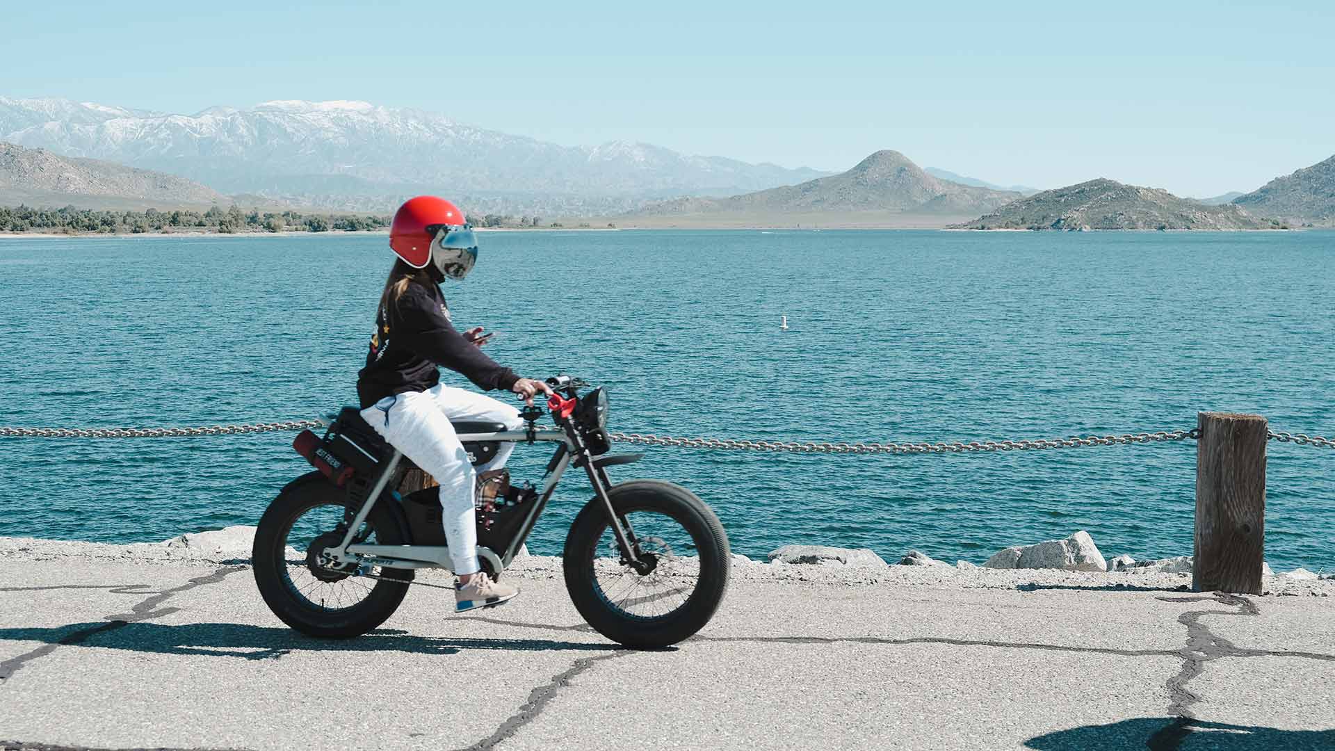 Super73 rider on Lakeside board walk wearing red helmet 