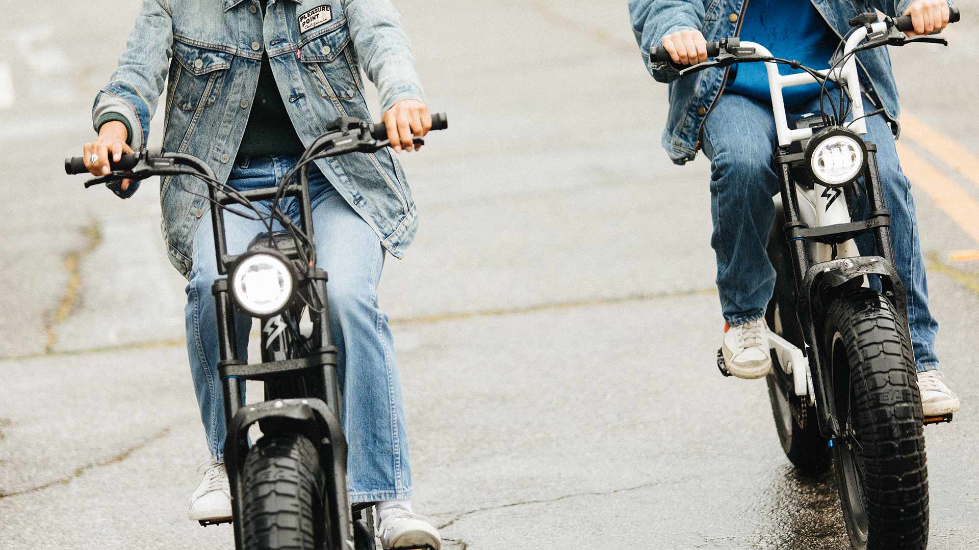 A pair of Super73 S2 ebikes being riden by riders in all denim