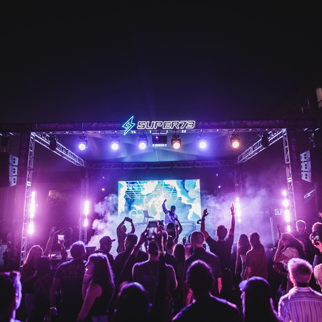 Live concert performance with illuminated Super73 logo above stage