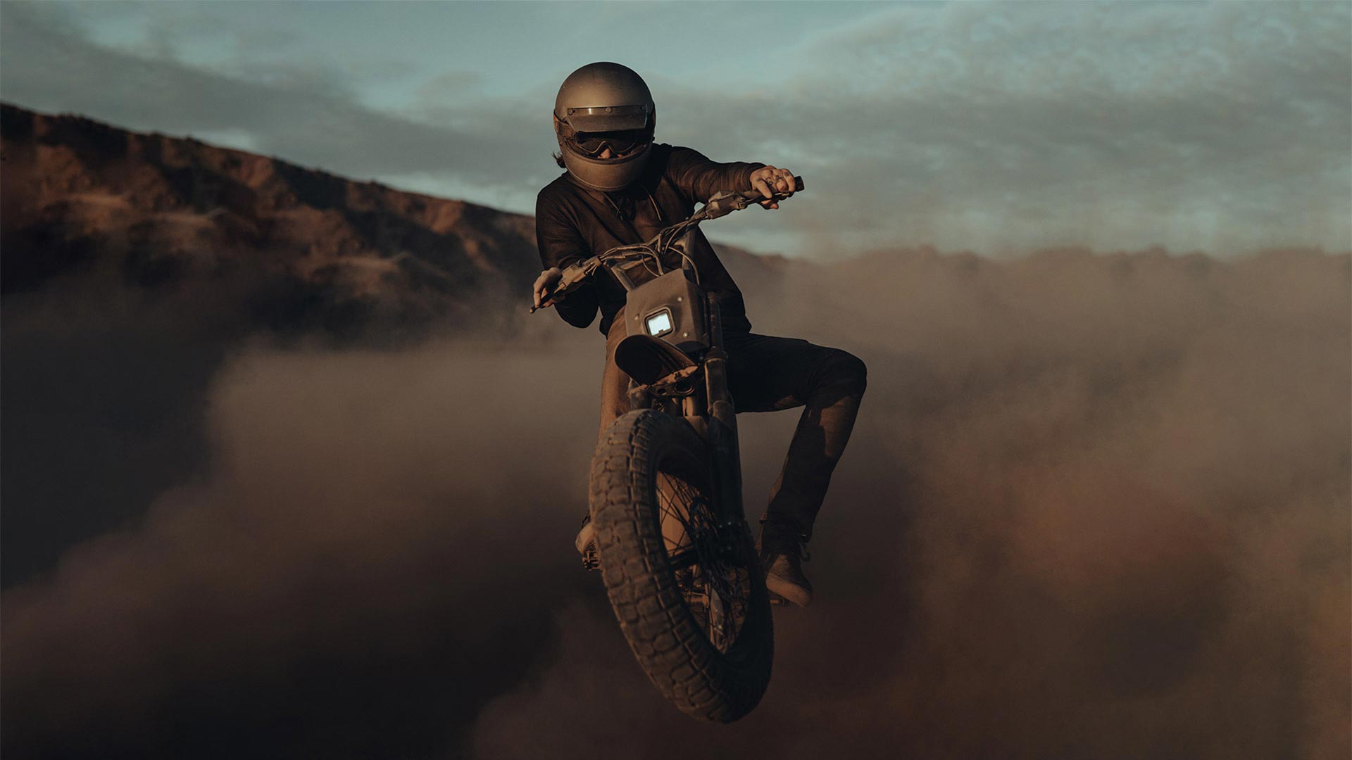 Super73 riding in the sand doing tricks.