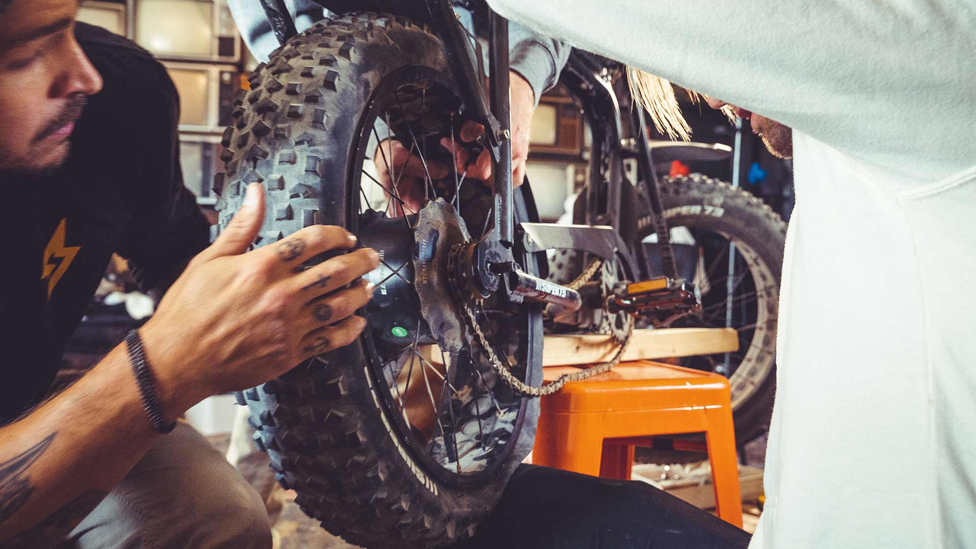 A man repairing a flat tire on a SUPER73.