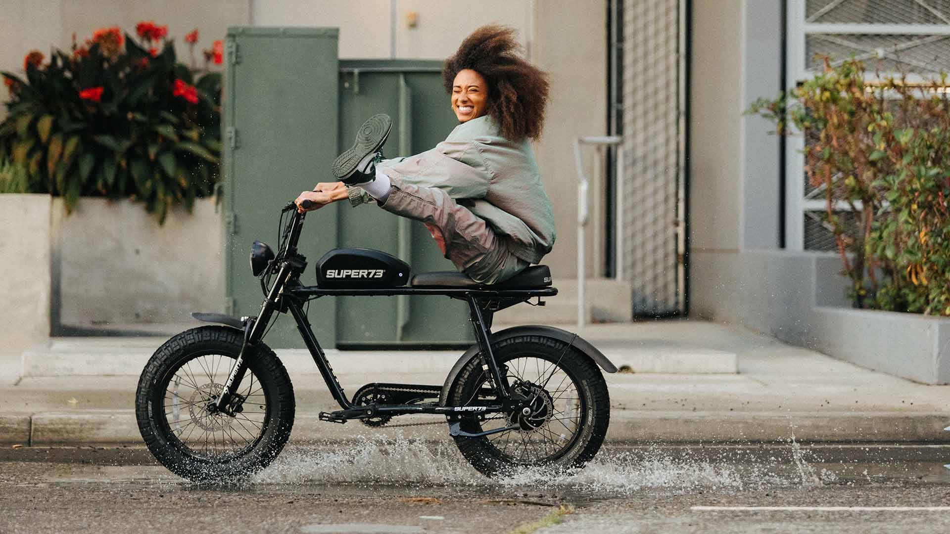 Rider with feet up blasting through a street puddle