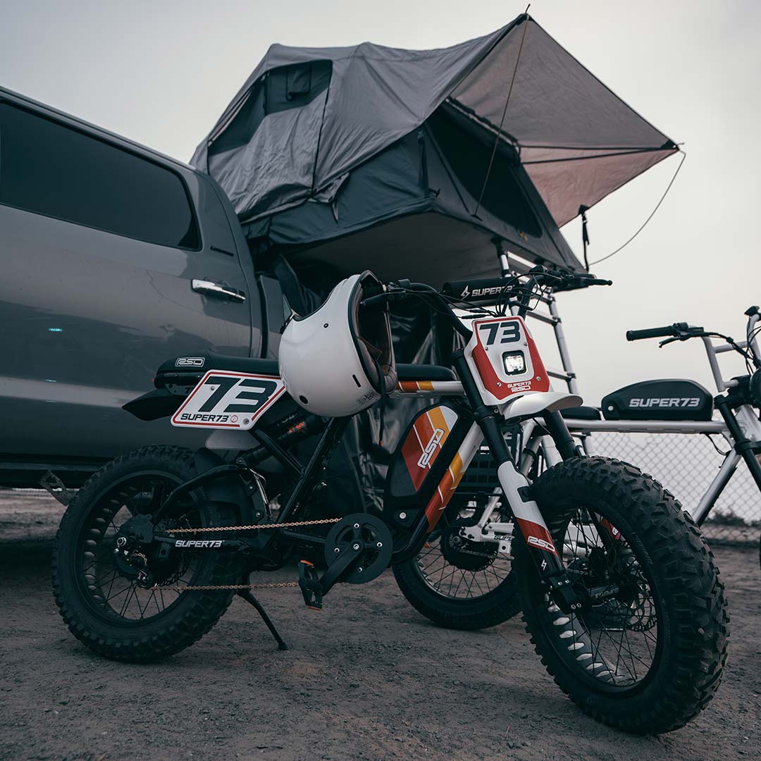 Lifestyle image of RSD x SUPER73 RX Malibu on a beach camping grounds