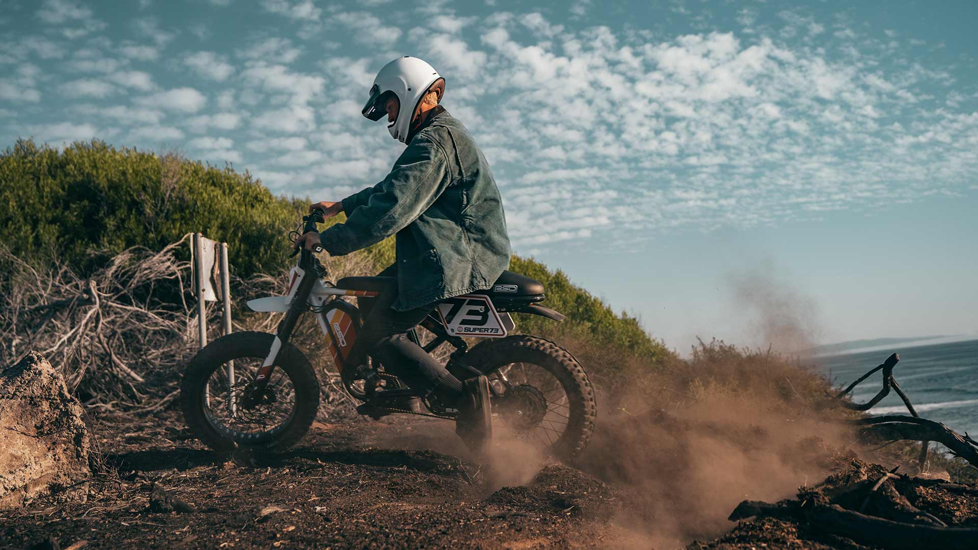 Super73 RSD ebike rider riding on a coastal dirt path wearing a helmet