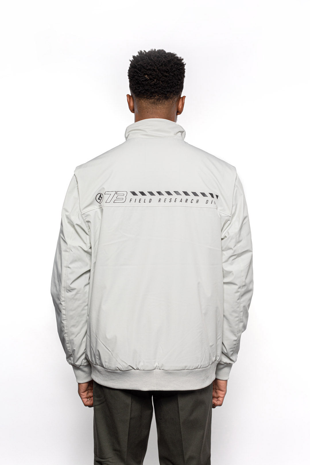 Back view of Male model wearing Royce Harrington Jacket in Chalk colorway.