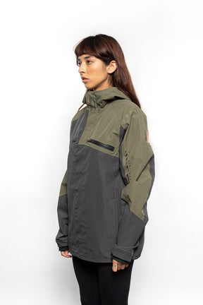 Side view of Female model wearing Vale Packable Anorak in Dark Fatigue colorway.